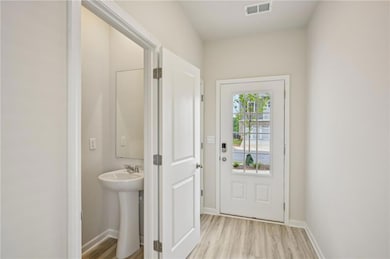 Doorway featuring baseboards, visible vents, and l