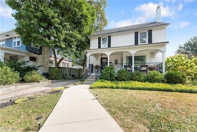 View of front facade with a porch, a chimney, and a front yard