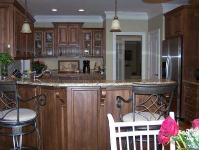 Kitchen with all stainless steel appliances, granite countertops, custom cabinets, bar for stools and breakfast table.