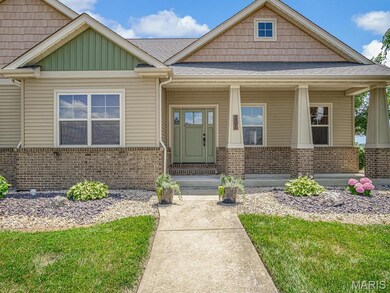 Craftsman-style home featuring brick siding, a porch, and a shingled roof