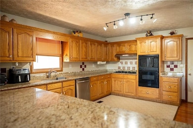 Kitchen featuring decorative backsplash, sink, sta
