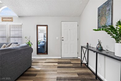 Entrance foyer with a textured ceiling, dark wood-