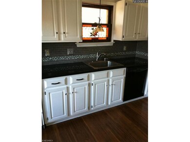 Newly updated eat-in kitchen with granite counters, hardwood floors and glass tile backsplash!