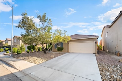 View of front of home with stucco siding, concrete driveway, an attached garage, and a tiled roof