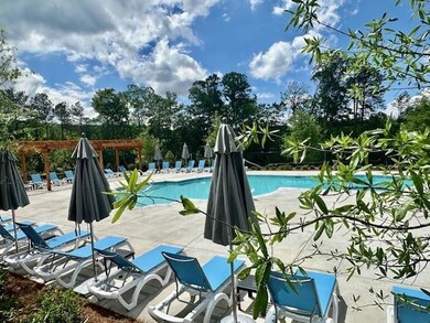 Community pool featuring a patio area and a pergol