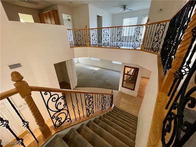 Stairway featuring a ceiling fan and tile patterne