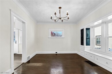 Spare room with dark hardwood / wood-style floors, an inviting chandelier, and crown molding