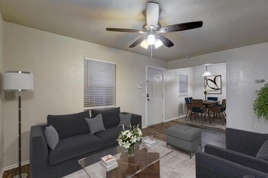 Living room featuring ceiling fan and hardwood / w