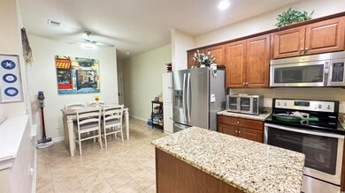 Kitchen with ceiling fan, light tile patterned flo