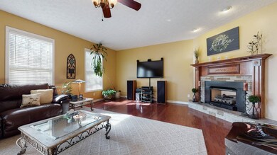 The expansive Living Room features Engineered Hardwoods, high ceilings and a Gas Fireplace with stone façade and gorgeous wooden mantle.
