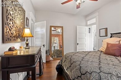 Bedroom with ceiling fan and dark wood finished floors