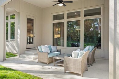 Covered patio overlooks the pretty treed backyard