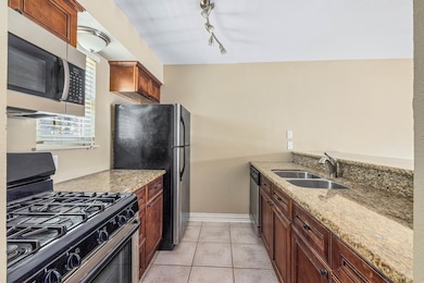 Modern kitchen with granite countertops, gas range, and plenty of cabinet space—perfect for everyday cooking or entertaining. Sleek, functional layout with stainless appliances and natural light