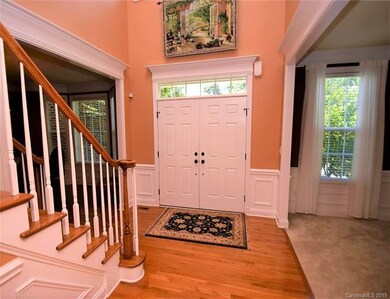 Double door entry with wood foyer and stairs