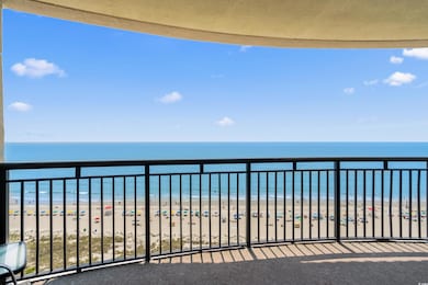 Balcony featuring view of water and beach