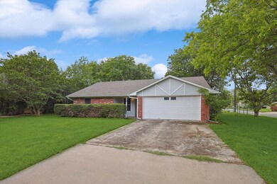 Single story home with a garage and a front lawn