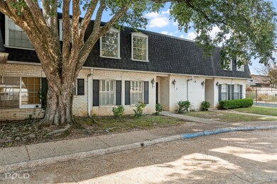 View of front of property with roof with shingles, mansard roof, and brick siding