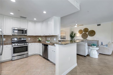 Kitchen with appliances with stainless steel finishes, a peninsula, ornamental molding, backsplash, and dark stone countertops