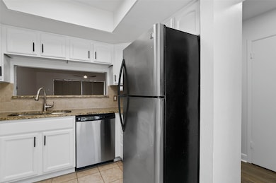 Modern kitchen with granite counter tops, decorative backsplash, and stainless appliances.  This condo features an open floor plan with a pass through window