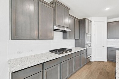 Kitchen featuring wall chimney range hood, applian