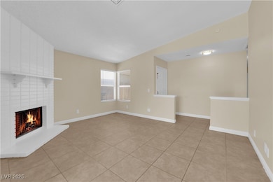 Unfurnished living room featuring a brick fireplac