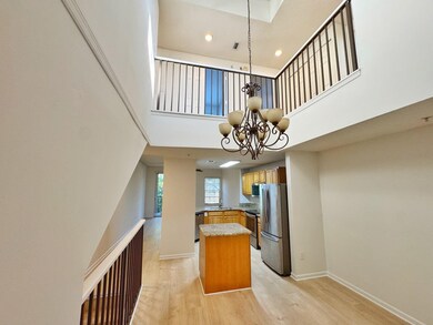 Kitchen with a high ceiling, stainless steel appliances, light wood finished floors, recessed lighting, and a kitchen island