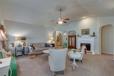 Living room has vaulted ceilings and a lovely fireplace.