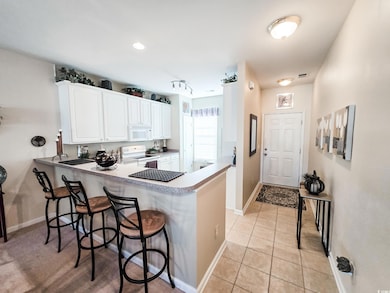 Kitchen with white appliances, a breakfast bar, wh