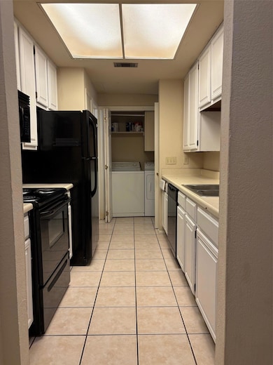 Kitchen with range, washer and dryer, light tile 