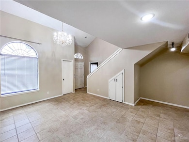 Unfurnished living room with a chandelier, a high ceiling, and light tile patterned floors