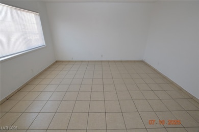 Spare room featuring baseboards and light tile pat