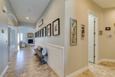 Hallway with ornate columns, baseboards, arched wa