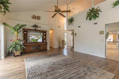 Grand Living Room With Sliders Leading To Private Patio, Opens To Kitchen
