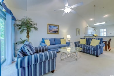 Living room featuring light colored carpet, ceiling fan, and vaulted ceiling