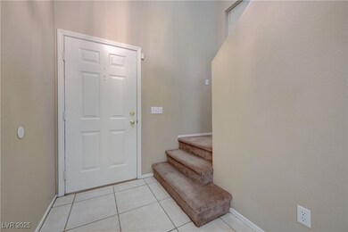 Entrance foyer with stairs and light tile patterne