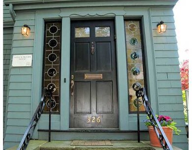 Exterior Front. Detail of front door with green bu