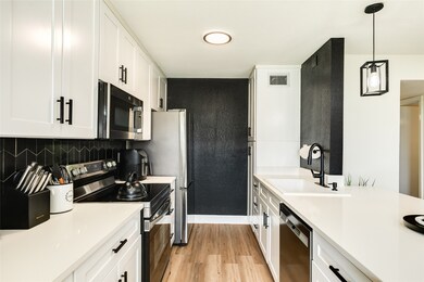 Spacious galley kitchen with beautiful white quart