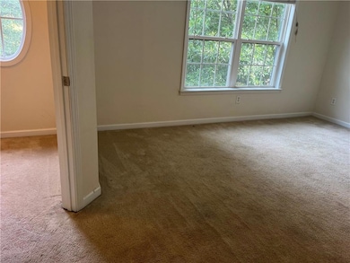 Empty room featuring plenty of natural light and light carpet
