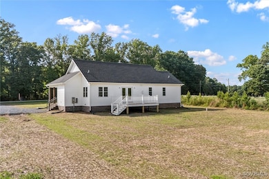 Back of property featuring a deck, a yard, roof wi