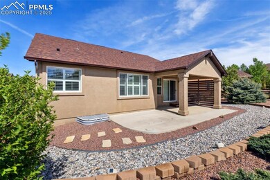 Back of property featuring stucco siding, a patio area, and roof with shingles