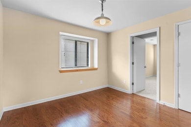 Empty room featuring wood finished floors and baseboards