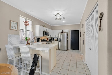 Kitchen featuring a peninsula, a kitchen bar, appl