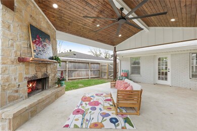 View of patio with an outdoor stone fireplace, fen