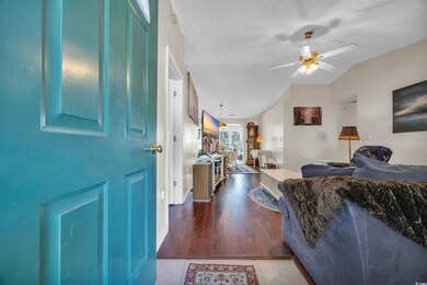 Living room with ceiling fan, dark wood-type floor