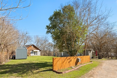View of yard featuring dirt driveway, a shed, an 
