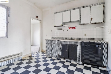 Kitchen featuring tile patterned floors, dishwasher, plenty of natural light, and white cabinets