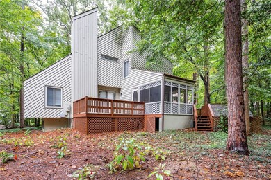 Back of house featuring a sunroom and a deck