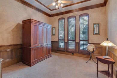 Gorgeous Study Offers a Faux Finish, Wainscoting, Arched Windows with Plantation Shutters and a Custom Ceiling Treatment with Double Crown Moulding.