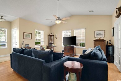 Living room featuring lofted ceiling, ceiling fan,