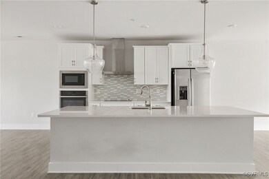 Kitchen featuring wall chimney range hood, an isla